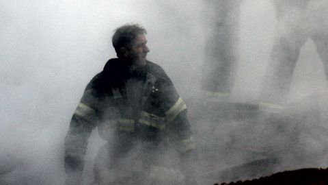 New York, N.Y. (Sept. 14, 2001) -- A fire fighter emerges from the smoke and debris of the World Trade Center. The twin towers of the center were destroyed in a Sep. 11 terrorist attack. U.S. Navy Photo by Photographer's Mate 2nd Class Jim Watson. (RELEASED)