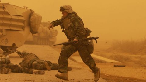 FILE - U.S. Marines with 3rd Battalion, 7th Marines, 1st Marine Division, take cover after a mortar attack during a sandstorm on a road south of Baghdad, Iraq on Wednesday, March 26, 2003. (AP Photo/Laura Rauch, File)