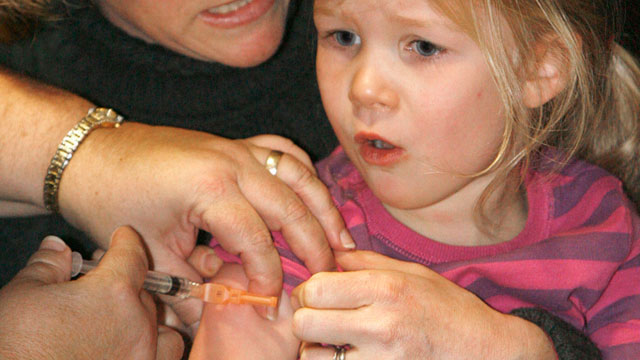 Melinda Anderman of Duxbury holds her four and a half-year-old daughter, Margaret, as she gets an H1N1 vaccination during a flu clinic in Montpelier, Vermont, November 2009. (AP Photo/Toby Talbot, File)