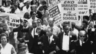 Dr. Martin Luther King, Jr. marches in a line of men with arms linked during the March on Washington. August 1963. (AP Photo)