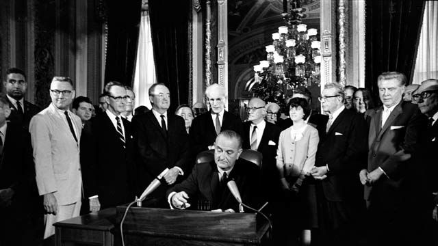 President Lyndon B. Johnson signs the Voting Rights Act of 1965 in a ceremony in the President's Room near the Senate chambers in Washington, D.C. August 1965. (AP Photo)