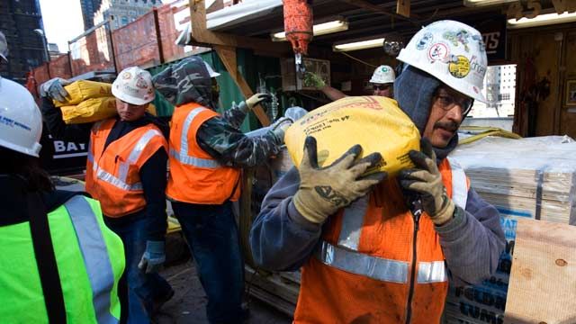 Construction workers carry supplies at the World Trade Center site in New York. October 2008. (AP Photo/Mark Lennihan)