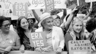 Bella Abzug smiles as she holds up her ERA sign in a pro-equal rights demonstration on New York's Fifth Avenue. August 1980. (AP Photo)