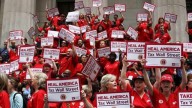 Nurses from the National Nurses United union protest for the Robin Hood Tax