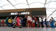 Olympic athletes queue up at the McDonalds inside the dining hall at the Olympic Village in London. July 2013. (AP Photo/Bullit Marquez)