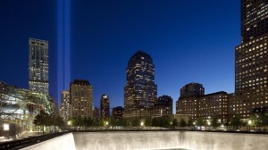 The Tribute in Light, left, shines above a reflecting pool at the National Sept. 11 Memorial, Tuesday, Sept. 11, 2012 in New York. (Photo by Mark Lennihan/AP)