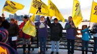 Rally participants hold flags on the waterfront in the East Boston neighborhood in advance of a possible strike. The rally was organized by the Service Employees International Union that represents 14,000 New England janitors. September 2012. (AP Photo/Michael Dwyer)