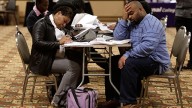 Tonya Crenshaw and Kendrick Haraalson fill out applications at a job fair in Brookpark, Ohio. (AP Photo/Tony Dejak)