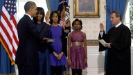 President Barack Obama is officially sworn-in by Chief Justice John Roberts in the Blue Room of the White House during the 57th Presidential Inauguration in Washington, Sunday Jan. 20, 2013. Next to Obama are first lady Michelle Obama, holding the Robinson Family Bible, and daughters Malia and Sasha. (AP Photo/Pool, Charles Dharapak)