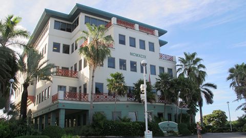 In this Aug. 3, 2012 photo, the Ugland House, the registered office for thousands of global companies, stands in George Town on Grand Cayman Island. The Cayman Islands have lost some of their allure by abruptly proposing what amounts to an income tax on expatriate workers who have helped build the territory into one of the most famous or, for some people, notorious offshore banking centers that have tax advantages for foreign investment operations. (AP Photo/David McFadden)