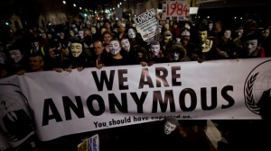 Anonymous supporters wearing Guy Fawkes masks pause for fellow protesters and members of the media to film and photograph them with a banner as they take part in a protest march along Whitehall to Britain's Houses of Parliament in London, Monday, Nov. 5, 2012. The protest was held on November 5, to coincide with the failed 1605 gunpowder plot to blow up the House of Lords. (AP Photo/Matt Dunham)