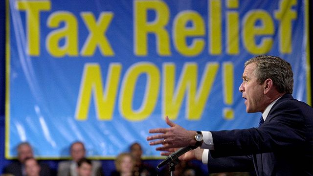 President Bush touts his tax cut plan to a crowd at Lafayette Regional Airport, before departing, Friday, March 9, 2001, in Lafayette, La. The president will spend the weekend at his ranch in Crawford, Texas. (AP Photo/Kenneth Lambert)