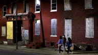 In this March 29, 2013 photo, women walk past blighted row houses in Baltimore. Baltimore is far from the worst American city for poverty, but it faces all the problems of cities where vast numbers of the poor now live. The U.S. Census Bureau puts the number of Americans in poverty at levels not seen since the mid-1960s, while $85 billion in federal government spending cuts that began last month are expected to begin squeezing services for the poor nationwide. (AP Photo/Patrick Semansky)