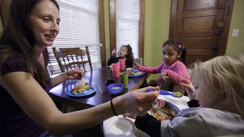 In this photo taken Nov. 23, 2009, Lisa Zilligen, 28, serves lunch to her three children, Miles, 20 months, Olivia 6, left, and Danielle, 8, in her home in Chicago. Zilligen, a single mother and full-time student at Loyola University has been getting food stamps for the past several months; sometimes the allotment runs out before the end of the month and the family ends up visiting a food pantry. (AP Photo/M. Spencer Green)
