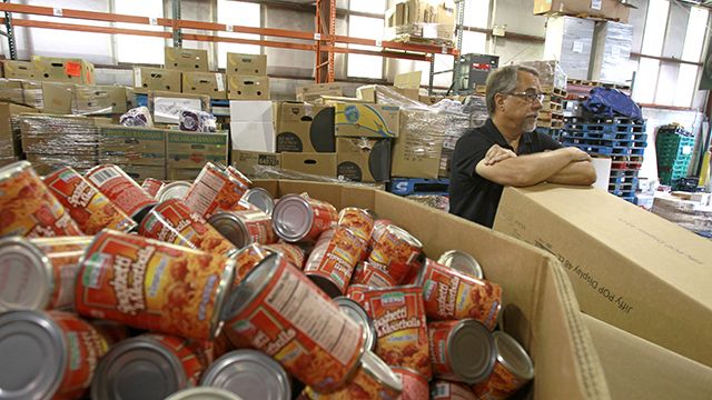 In this Monday, July 30, 2012 photo, Dave Krepcho, director of the Second Harvest Food Bank, looks over a supply of goods that have arrived at the food bank warehouse in Orlando, Fla. In the past four years, food distribution to 500 pantries, shelters, and other relief agencies in the six-county area has jumped about 60 percent. In the last year alone, that amounted to 36 million pounds of food. Krepcho estimates about 30 percent of those seeking help are first-timers. They're blue-collar and white-collar, many middle class, even some upper middle class. They include college-educated couples and professionals. (AP Photo/John Raoux)