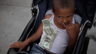 Four-year-old Nathan Hobbs, who lives in a homeless shelter with his mother, sits in a stroller with one-dollar bills he received for his birthday pinned to his chest in Los Angeles, Wednesday, September 14, 2011. (AP Photo/Jae C. Hong)