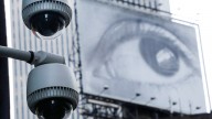 Security cameras are mounted on the side of a building overlooking an intersection in midtown Manhattan, Wednesday, July 31, 2013 in New York. In the background is a billboard of a human eye. (AP Photo/Mark Lennihan)