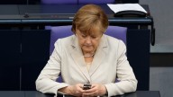 German Chancellor Angela Merkel uses her mobile phone at the German Federal Parliament Bundestag in Berlin, Germany. Merkel is among the world leaders who are trying to cope following allegations of massive electronic monitoring by the U.S. National Security Agency in Berlin. (AP Photo/Markus Schreiber)
