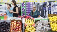 Customers check out prices of the high quality fresh produce in the store. (Michael Stravato/ AP Images for ALDI)