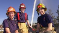 Tacoma Fire Dept. firefighters Gayle Nikolaisen, left, Lt. Jennifer Gunnell and Karen Leming pose atop their fire engine Sunday, March 3, 2002. (AP Photo/Elaine Thompson)