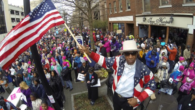 Holiday Clinkscale II waves an American flag as he joins thousands of people of protesters in downtown downtown Raleigh, N.C., Saturday Feb. 8, 2014. Nearly 200 organizations are joining the National Association for the Advancement of Colored People in the "Moral March on Raleigh," a new name for the "Historic Thousands on Jones Street," as it was originally called. Jones Street referred to the street where the Legislative Building stands and the usual terminus of the march. Advocates are angry about bills Gov. Pat McCrory has signed into law, including the refusal to expand Medicaid under the federal health care law; a reduction in unemployment benefits; an elections-overhaul law that requires photo identification to vote in person; the elimination of the earned income tax credit; and taxpayer-funded grants for low-income children to attend private K-12 schools. (AP Photo/The News & Observer, Chuck Liddy)