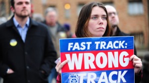 A protester holds a sign against the fast-track authority for the TPP during a protest in Portland, Oregon, on January 31, 2014. (Photo by Alex Milan Tracy/NurPhoto/Sipa USA) (Sipa via AP Images)