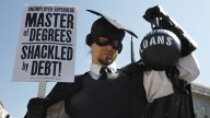 HOLD FOR RELEASE UNTIL 12:01 A.M. EDT. THIS PHOTO MAY NOT BE PUBLISHED, BROADCAST OR POSTED ONLINE BEFORE 12:01 A.M. EDT. - In this Oct. 6, 2011 photo, Gan Golan, of Los Angeles, dressed as the "Master of Degrees," holds a ball and chain representing his college loan debt, during Occupy DC activities in Washington. As President Obama prepared to announce new measures Wednesday to help ease the burden of student loan debt, new figures painted a demoralizing picture of college costs for students and parents: Average in-state tuition and fees at four-year public colleges rose an additional $631 this fall, or 8.3 percent, compared with a year ago. (AP Photo/Jacquelyn Martin)