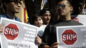 Former fast food worker Angel Santos, center, holds his 1-year-old daughter, Elisa, during a protest outside a McDonald's restaurant on Tuesday, March 18, 2014, in Huntington Park, Calif. Protesters were set to rally outside McDonald's restaurants in cities including Boston, Chicago and Miami to call attention to the denial of overtime pay and other violations they say deprive workers of the money they're owed. (AP Photo/Jae C. Hong)