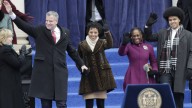 New York City Mayor-elect Bill de Blasio, left, arrives with his family Chiara de Blasio, second from left, Dante de Blasio, center, right, Chirlane McCray to take the oath of office in on the steps of City Hall, Wednesday, Jan. 1, 2014, in New York. (AP Photo/Frank Franklin II)