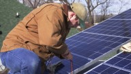 Ben Gerald from Staley Electric Co. helps install solar power panels on the roof of a house in North Little Rock, Arkansas on Wednesday, January 22, 2003. (AP Photo/David Quinn)