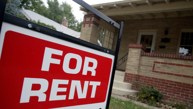 For rent sign stands sentry outside an existing home on the market in the Country Club area southeast of downtown Denver. (AP Photo/David Zalubowski)