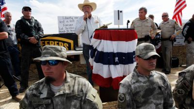 Rancher Cliven Bundy, middle, addresses his supporters along side Clark County Sheriff Doug Gillespie, right, on April 12, 2014. (AP Photo/Las Vegas Review-Journal, Jason Bean)