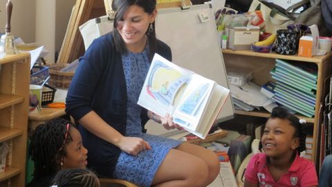 In this April 10, 2014 file photo, student teacher Franchesca Moreno, 21, reads to Andreanna Thomas, 6, right, and Alana Cawthon, upper left, at Bennett Park Montessori School in Buffalo, NY. (AP Photo)