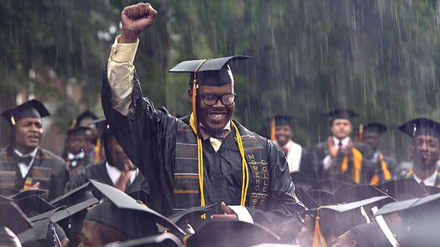 Graduate Frederick Anderson stands in the pouring rain as President Barack Obama acknowledges him during the Morehouse College 129th Commencement ceremony, Sunday, May 19, 2013, in Atlanta. (AP Photo/Carolyn Kaster)