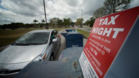 There was a steady stream of post office customers dropping off mail including their tax forms at the Pembroke Pines, Fla., Tuesday, April 15, 2014. The post office placed signs on the mail boxes to inform patrons about times. (AP Photo/J Pat Carter)