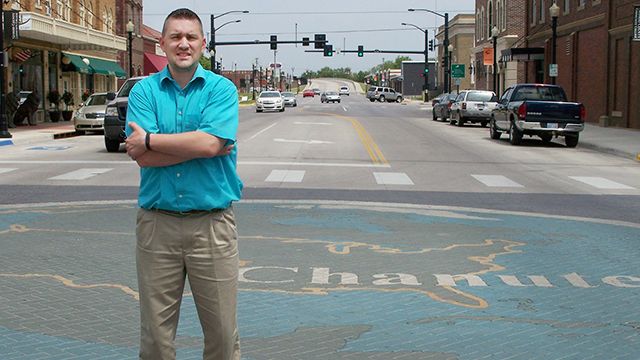 Chanute Mayor Greg Woodyard stands on a brick mosaic of the Google Earth logo at the intersection of Lincoln and Main streets on May 21, 2014. on May 19, 2014 in Chanute, Kan.