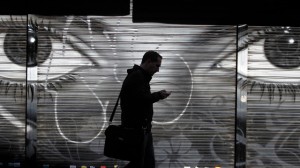 A man looks at his cell phone as he walks on the street in downtown Madrid, on Oct. 31, 2013, days after allegations surfaced that the NSA spied on more than 60 million phone calls in Spain in one month alone. (AP Photo/Francisco Seco)