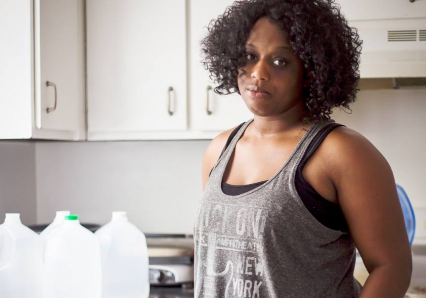 Charleston resident Anoa Changa stands next to her stock of bottled water. (Photo: David Stephenson/In These Times).