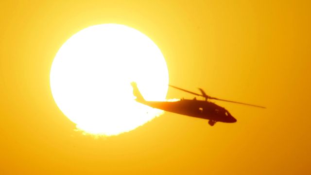 A U.S. Army Black Hawk helicopter flies as the sun sets over the heavily fortified Green Zone in Baghdad, Iraq, Tuesday, Dec. 19, 2006. A Marine died Monday from wounds sustained from enemy action in Iraq's western Anbar province, which brought to 61 the number of American military personnel killed in Iraq in December. (AP Photo/Darko Vojinovic)