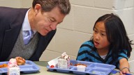 n this Jan. 23, 2014 file photo Kansas Gov. Sam Brownback, left, leans in to listen to Xen Hesse as the two each lunch at Roesland Elementary School in Roeland Park, Kan. On Friday, March 7, 2014, the Kansas Supreme Court said the state's current public school funding levels are unconstitutional. The case has broader implications beyond the classroom: Kansas enacted sweeping cuts to income taxes championed by Brownback that have reduced the amount of available resources to comply with a court order. (AP Photo/John Milburn, File)