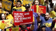 Protesters rally for an increase in the minimum wage on the Great Western Staircase at the Capitol on Tuesday, June 17, 2014, in Albany, N.Y. Several hundred fast-food workers and other low-wage employees from around New York gathered to pressure lawmakers to raise the minimum wage from $8 to $10.10 an hour and let local cities raise it even higher. (AP Photo/Mike Groll)