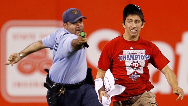 A law enforcement officer chases down Steve Consalvi, who ran on to the field before the eighth inning of a baseball game between the Philadelphia Phillies and the St. Louis Cardinals, Monday, May 3, 2010, in Philadelphia. St. Louis won 6-3. The officer used a Taser gun to apprehend Consalvi. (AP Photo/Matt Slocum)