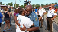 Capt. Ronald Johnson of the Missouri Highway Patrol hugs Angela Whitman, of Berkeley, Mo., on West Florissant Avenue in Ferguson, Mo., on Thursday, Aug. 14, 2014. (AP Photo/St. Louis Post-Dispatch, David Carson)