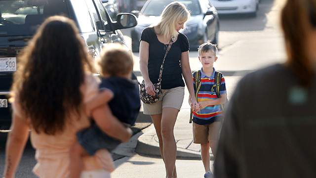 Escorted by his mother Deborah, first grader Charlie Verucchi arrives for his first day of school at Lewisburg Primary School in Olive Branch, Mississippi. (AP Photo/The Commercial Appeal, Stan Carroll)