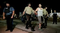 A man is lead away by police during a protest Monday, Aug. 18, 2014, for Michael Brown, who was killed by a police officer Aug. 9 in Ferguson, Mo. Brown's shooting has sparked more than a week of protests, riots and looting in the St. Louis suburb. (AP Photo/Charlie Riedel)