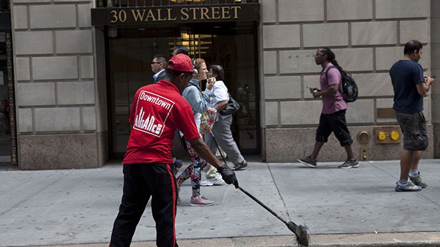 A worker sweeping the street in Wall Street. (Credit: Charina Nadura)