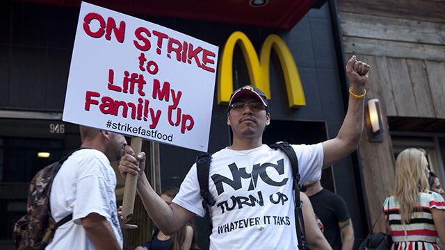 On September 4, 2014, a protester holding a sign that says "On Strike to Lift My Family Up" was in front of McDonald restaurant near Columbus Circle. In New York City, 21 fast food workers were arrested that day in an organized nationwide strike to demand $15-an-hour and a union. (Photo: Charina Nadura/ Moyers & Company)