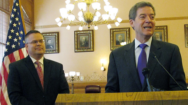 Kansas Gov. Sam Brownback, right, who has made eliminating "liberal" justices one of his central campaign promises, appointed Caleb Stegall, left, to the Kansas Supreme Court in August 2014.