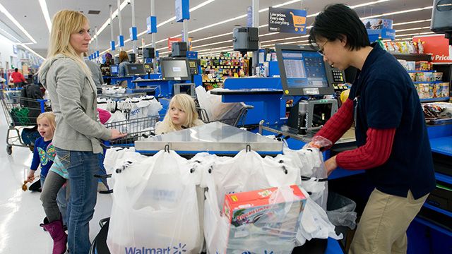 Grace Tan, right, bags up a grocery purchases for Angela Coffer and her daughters at a Gladstone, Missouri, Walmart. (Photo: Walmart/flickr CC 2.0)