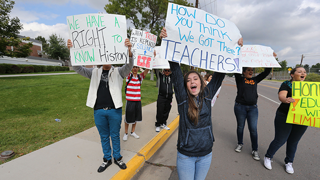 Students protest against a Jefferson County School Board proposal to emphasize patriotism and downplay civil unrest in the teaching of US history, in front of their school, Jefferson High, in the Denver suburb of Edgewater, Monday, Sept. 29, 2014. (AP Photo/Brennan Linsley)